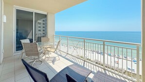 A balcony with a view of the beach and ocean.