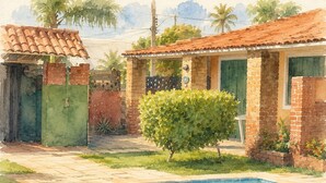 A swimming pool with a tiled edge, a brick house with a tiled roof, and a green bush.