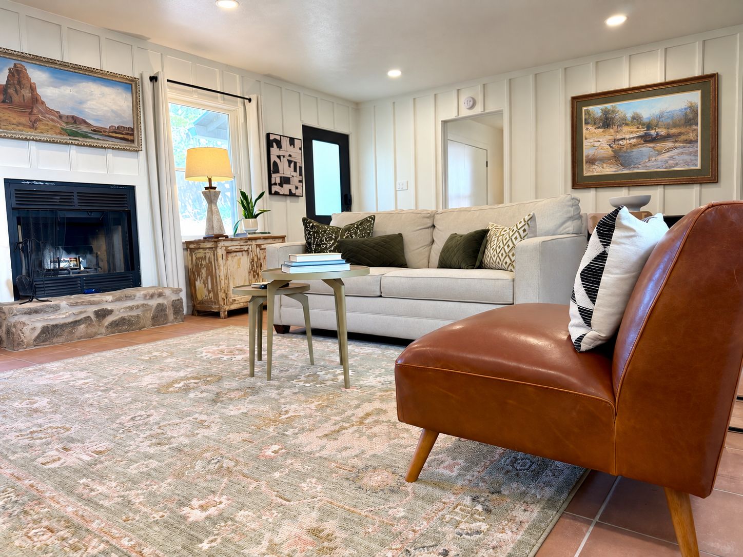 A living room with a fireplace, sofa, coffee table, and decorative pillows.