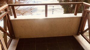 A balcony with a tiled floor and wooden railings. - MH Apartaments (Bansko)