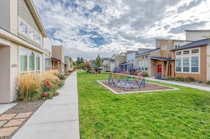 A residential area with modern houses, a playground, and a well-maintained lawn.