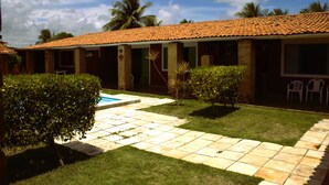 A building with a tiled roof, a swimming pool, and a well-maintained lawn. - House with 10 suites - Sleeps 20 adults - 100m from the sea - Serrambi Beach (Ipojuca)