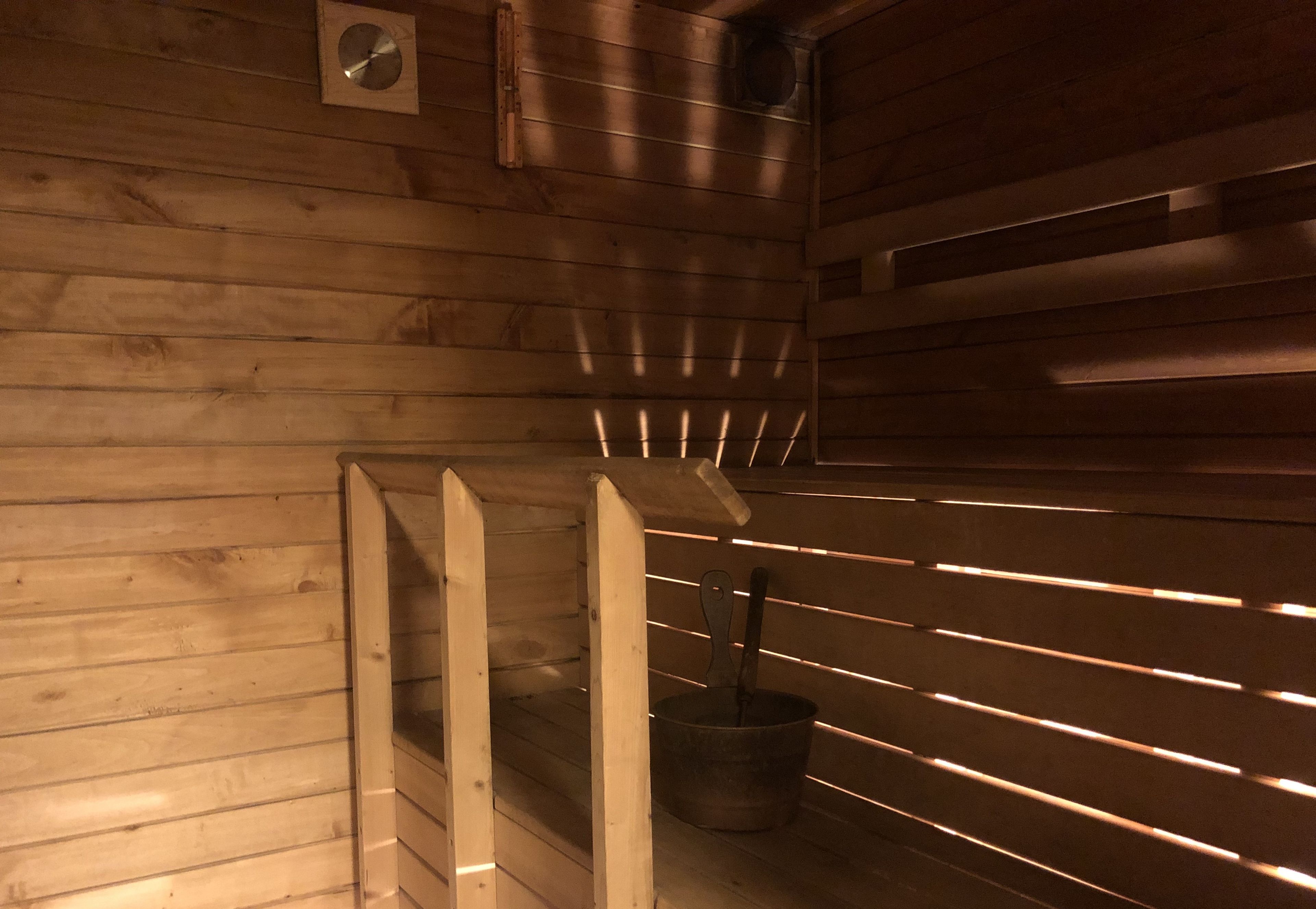 Uma sauna com paredes de madeira e bancos ripas.