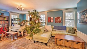 Una sala acogedora con un piano, un árbol de Navidad y un sofá.