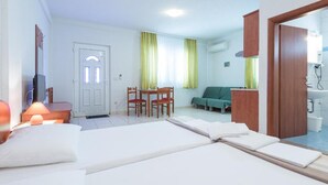 Hotelkamer met een bed, bureau, stoel, bank en een badkamer zichtbaar door een geopende deur.