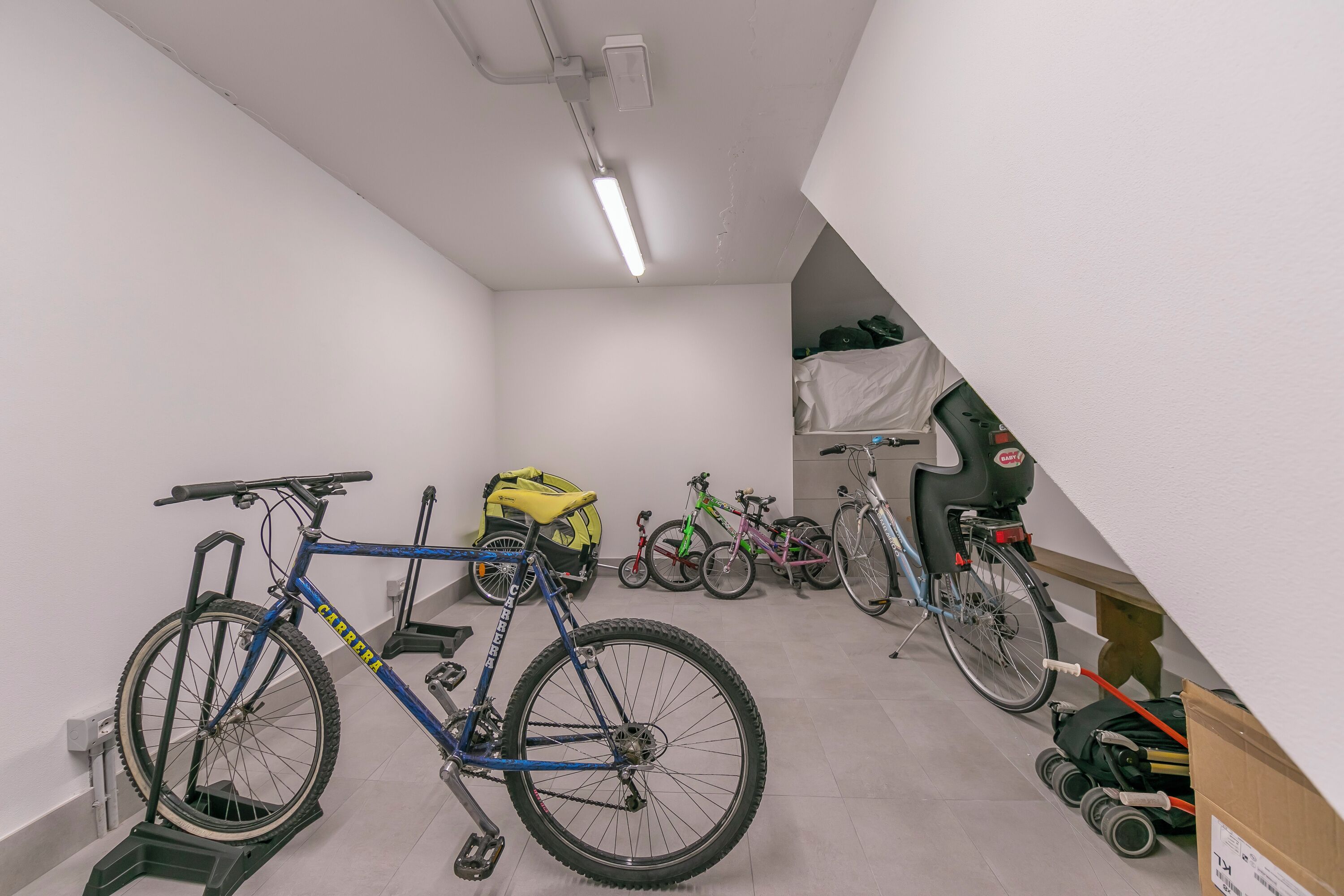A room with bicycles, a stepper, and a wheelchair.