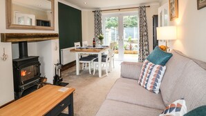 Una sala de estar acogedora con chimenea, una mesa de comedor y un sofá.