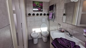 A modern bathroom with a toilet, bidet, and sink. - Apartment - Sleeps 2 - Parking - 5min To La Frasca (Civitavecchia)
