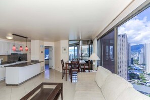 Ein modernes Apartment mit Küche, Essbereich und einem großen Fenster mit Blick auf die Stadt.