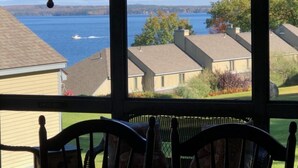 A view from a window overlooking a lake with houses in the background.