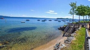 A clear view of a beach with boats in the water and a staircase leading down to the shore.