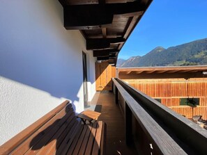 A wooden deck with a bench and a small table, overlooking a mountainous landscape. - Apartment Anna by Interhome (Fügen)