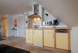 Una cocina compacta con horno integrado, microondas y lavavajillas.
