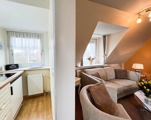 A compact living space with a kitchenette, a sofa, and a dining area. - Solbeck in the Käpitänshaus Andresen - Sylt is a valuable habitat and (Sylt)