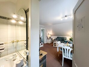Un espacio habitable compacto con baño, comedor y sala.
