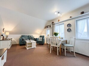 Un espacio habitable estilo loft acogedor, con comedor, sofá, una mesita y un radiador.