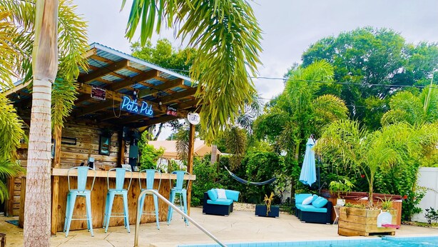 Un espace aménagé au bord de la piscine, comprenant un bar appelé « Polo Pub », des sièges en plein air et une piscine.