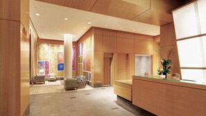 Una hall moderna con reception, area salotto e opere d'arte colorate alle pareti.