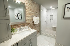 Een bad/douchecombinatie, een haardroger, handdoeken, zeep