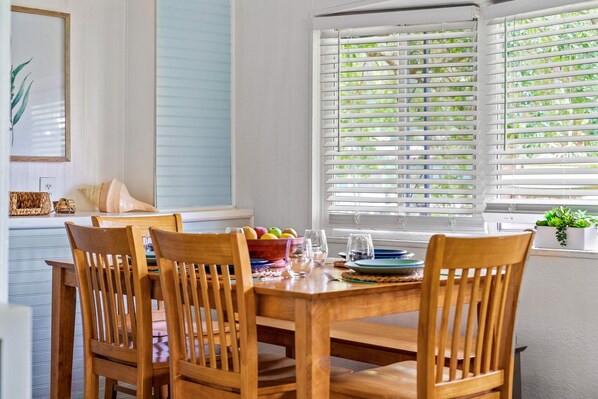 A dining area with a wooden table and chairs, a bowl of fruit, and a window with blinds. - Waterfront Front Row Seats to Nature’s Best Show (Spring Hill)