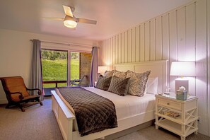A bedroom with a bed, a nightstand, a chair, and a view of the outdoors. - Sunburst in Sun Valley! Modern Family Getaway in Elkhorn. (Sun Valley)