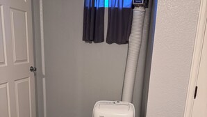 A room with a white door, a window with blue curtains, and a white portable heater. - 1 BRM Basement Apartment/ 420 friendly outside (Lakewood)