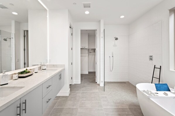A modern bathroom with a large mirror, a bathtub, and a shower area. - Private home: Open Space, Pool, Spa & Breathtaking Mountain View (Indian Wells)