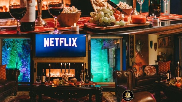 A cozy bar area with a Netflix sign, a fireplace, and various snacks and drinks. - 🛡Medieval Castle Hôtel ™ (McAllen)