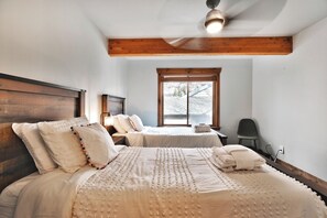 A bedroom with two beds, a ceiling fan, a window, and a chair. - Settler's Ridge #7 - On Deer Valley Drive - Easy Walk/Shuttle to Skiing and Main St. (Park City)
