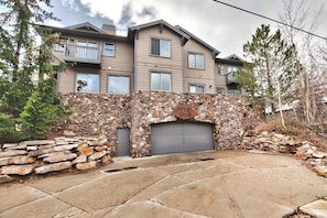 A two-story residential building with a stone facade, a garage, and a sign indicating 'Settler's Ridge.'