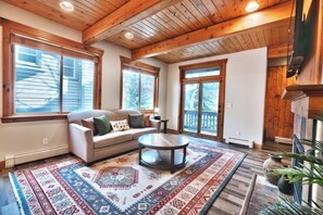 A cozy living room with a sofa, a coffee table, and a patterned rug.