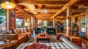 A spacious log cabin interior with a cozy living area, a kitchen, and a dining space. - Log Cabin with Stunning Views- Hot Tub, Sauna, BBQ, Patio Fireplace, Pets ok (Sevierville)