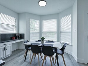 A modern kitchen with a dining table, chairs, and a coffee maker. - Newly Renovated Luxury 5BR – Family & Game Room (The Colony)