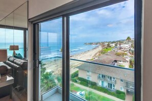 A balcony with a view of the beach and ocean.