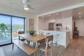 A modern kitchen with a central island, stainless steel appliances, and a view of the city.