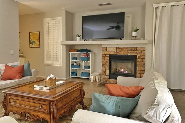A living room with a fireplace, a television, and a sofa.
