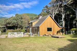 A wooden cabin with a sloped roof, a front porch, and a small deck. - Ocean View, Perfect for Agate Hunting! Dog Friendly! Fireplace! (Florence)