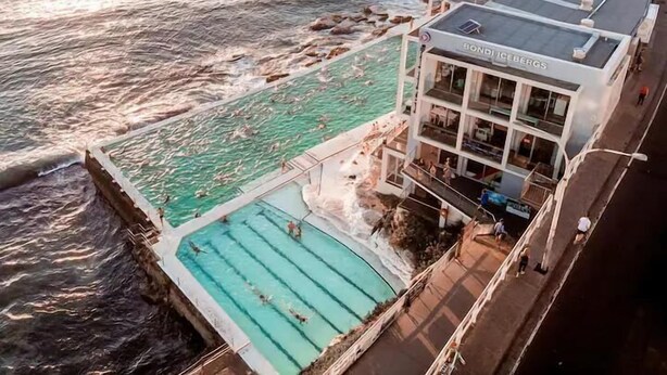 Ein Hotel an der Küste mit Schwimmbad, einem Gebäude mit Balkonen und Blick auf den Ozean.