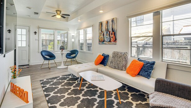 A modern living room with a white sofa, blue chairs, and a coffee table. - 1 Mi to Gulf Coast! Couples Retreat in Long Beach (Long Beach)