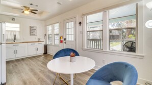 A modern kitchen with white cabinets, a ceiling fan, and large windows. - 1 Mi to Gulf Coast! Couples Retreat in Long Beach (Long Beach)