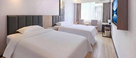 A hotel room with two beds, a desk, a chair, and a television.