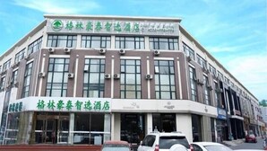 A hotel with a modern facade, large windows, and a prominent green logo. - Greentree Inn Langfang Guangyang District Guangyang Avenue North Yongxing Road Express Hotel (Langfang)