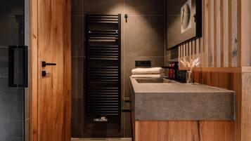 A modern bathroom with a wooden vanity, a towel rack, and a mirror.