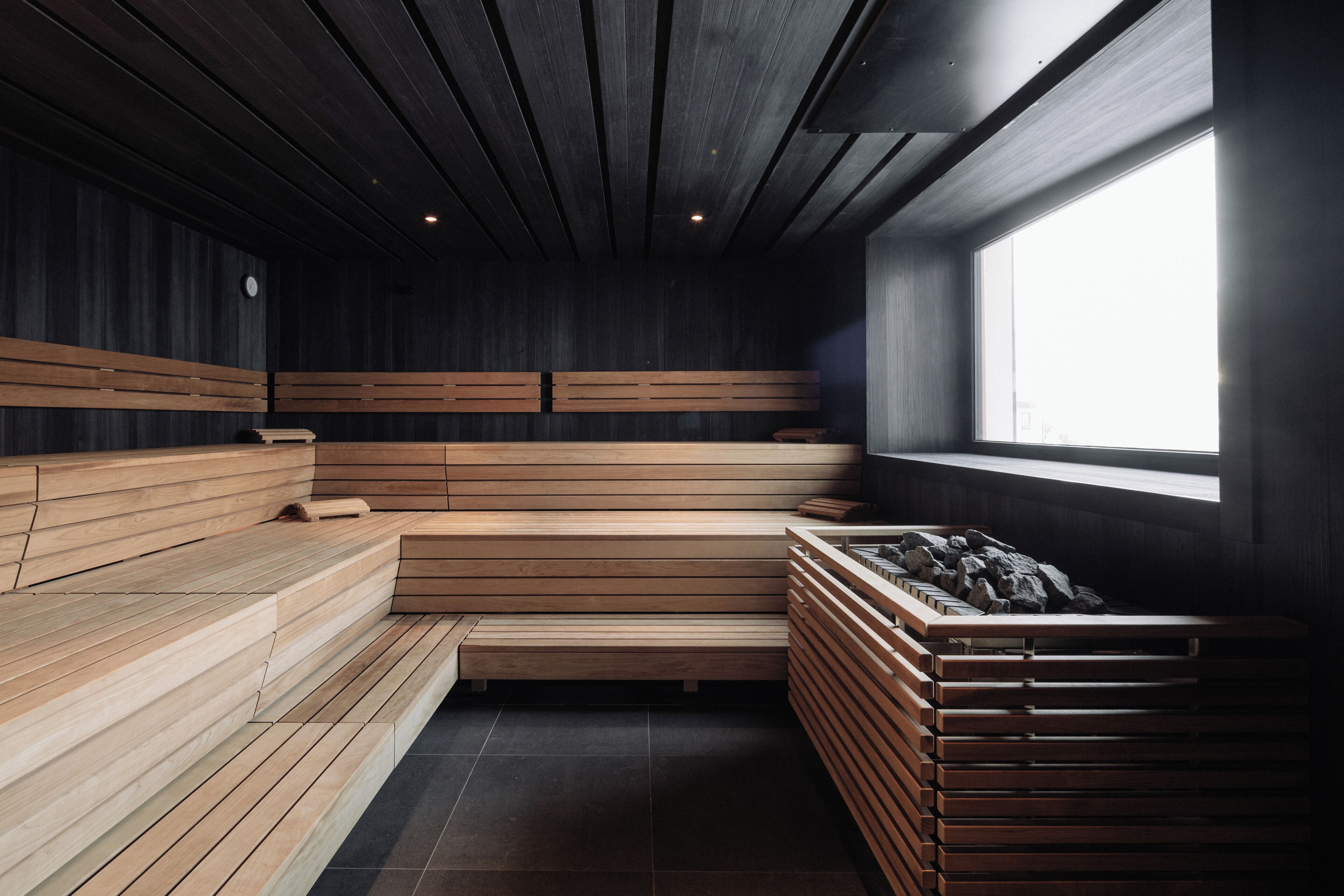 A sauna with wooden benches and a large window.