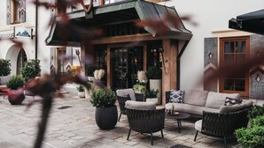 Un espace extérieur aménagé avec des meubles en osier et des plantes en pot.