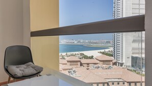 A modern room with a view of a beach and high-rise buildings. - Maison Privee - Premium Studio Apt in the Heart of JBR Beach, Dubai (Dubai)