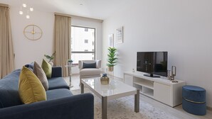 A modern living room with a sofa, coffee table, TV, and a large window. - Maison Privee - Premium Studio Apt in the Heart of JBR Beach, Dubai (Dubai)