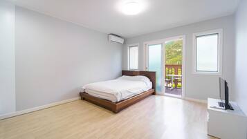 Ein Schlafzimmer mit Bett, Fenster und Klimaanlage.