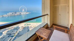 A balcony with a view of a beach, a Ferris wheel, and a cityscape. - Maison Privee - Sun Sand & Dubai Luxury at JBR Beach (Dubai)