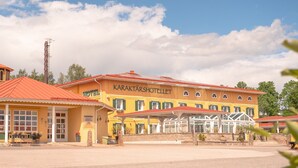 A yellow building with a red roof and a sign that reads "Karakterhotell". - Björkbackens Vandrarhem i Vimmerby - Hostel (Vimmerby)